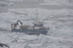 Barco abre seu caminho pelo gelo na costa de Ilulissat, na Groelândia